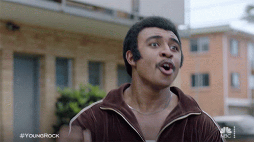 Man With Mustache In Front Of Building Hashtag YoungRock GIF