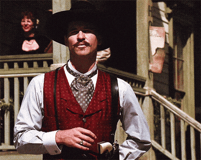 Man With Mustache In Red Vest And Suspenders Holding Gun GIF