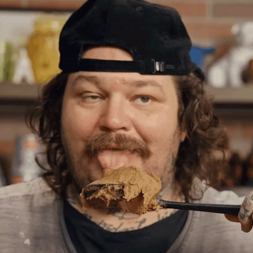 Man With Mustache Licking Spoonful Of Peanut Butter GIF
