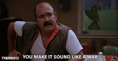 Man With Mustache Sitting At Table Saying You Make It Sound Like A War GIF