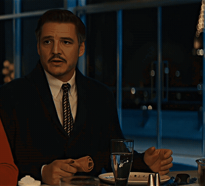 Man With Mustache Sitting at Table With Glass of Water