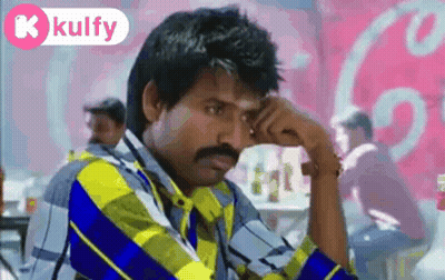 Man With Mustache Sitting In Front Of Coca Cola Sign GIF
