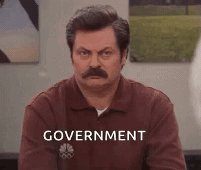 Man With Mustache Sitting In Front Of Government Wall GIF