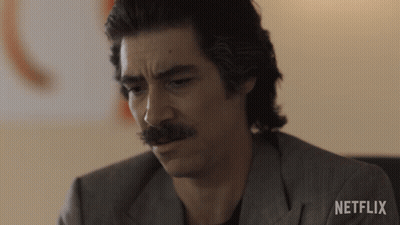 Man With Mustache Sitting In Front Of Netflix Wall GIF