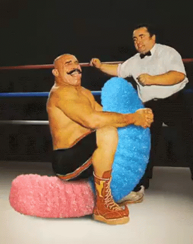 Man With Mustache Sitting On Pink And Blue Stuffed Animal GIF