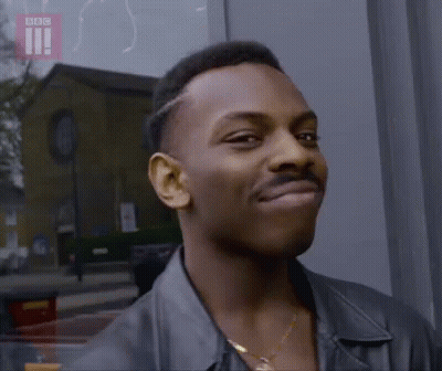 Man With Mustache Smiling At Camera In Front Of Building GIF