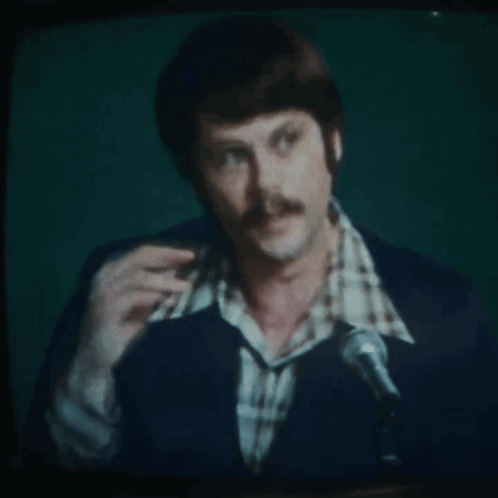 Man With Mustache Speaking Into Microphone On TV GIF