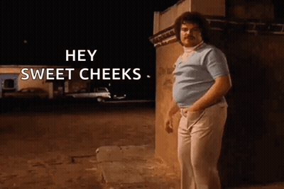 Man With Mustache Standing In Front Of Building At Night GIF