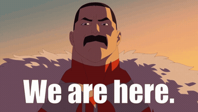 Man With Mustache Standing In Front Of We Are Here Sign GIF