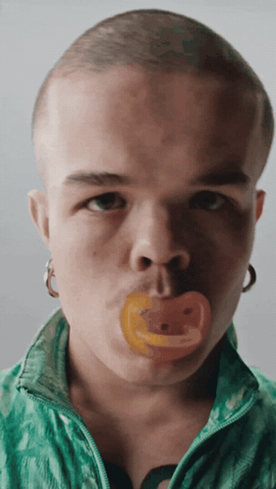 Man With Pacifier In Mouth Looking At Camera GIF