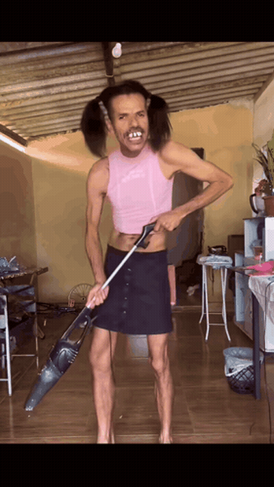 Man with Pigtails Holding Vacuum Cleaner