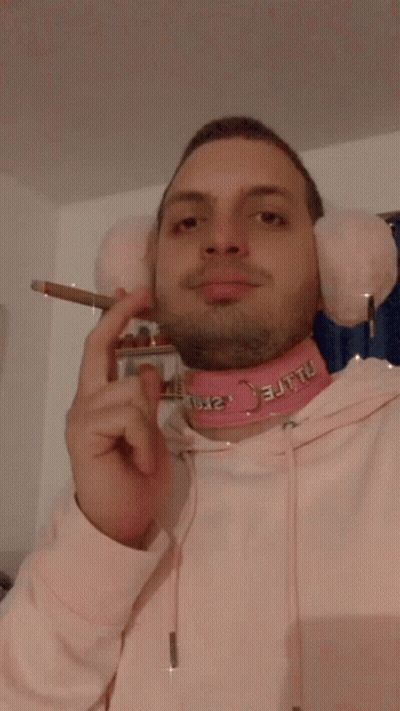 Man With Pink Ear Muffs And Choker Smoking GIF