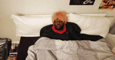 Man With Pink Hair Lying In Bed GIF