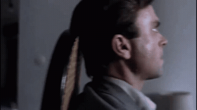 Man With Ponytail In Dark Room GIF
