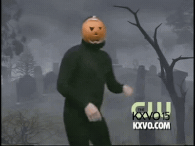 Man With Pumpkin Head Dancing In Front Of Cemetery GIF