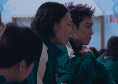 Man With Purple Hair Hugging Woman In Green Jacket GIF