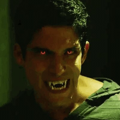 Man With Red Eyes And Vampire Teeth Smiling GIF