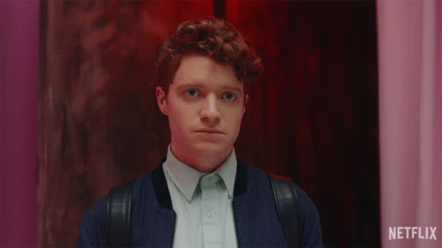 Man With Red Hair Smiling In Front Of Netflix Sign GIF