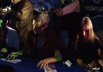 Man With Red Paint On Face At Table GIF