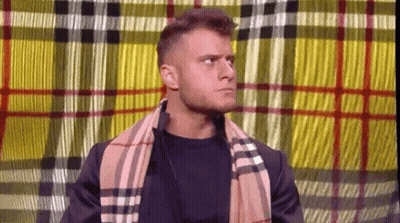 Man With Scarf And Plaid Jacket Before Plaid Curtain GIF