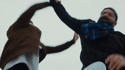 Man With Scarf Holding Another's Arm GIF