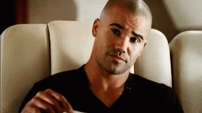Man With Shaved Head Sitting On Couch With Coffee GIF