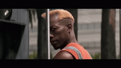 Man With Shaved Head Standing In Front Of Building GIF