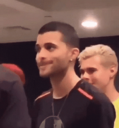 Man With Shaved Head Standing Next To Another GIF