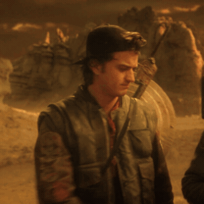 Man With Shield On Back Standing In Desert GIF