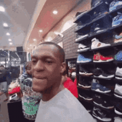 Man With Shoe Shelf In Shoe Store GIF