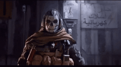 Man With Skull On Face In Front Of Wall With Arabic Writing GIF