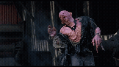 Man With Strange Face Standing In Dark Room Hands Outstretched GIF