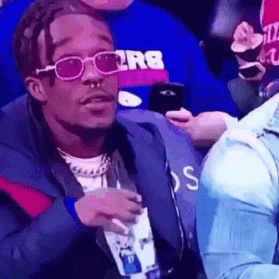 Man With Sunglasses And Nose Ring Holding Phone In Stadium GIF