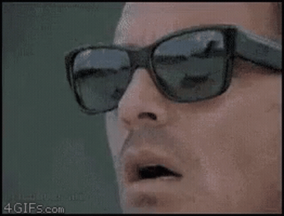 Man With Sunglasses Holding Scissors To Mouth GIF