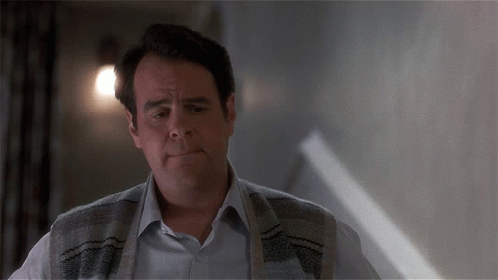 Man With Sweater Around Neck Looking At Something GIF