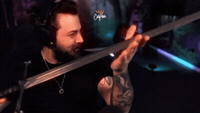 Man With Tattoo Holding Sword In Front Of Caliban Screen GIF