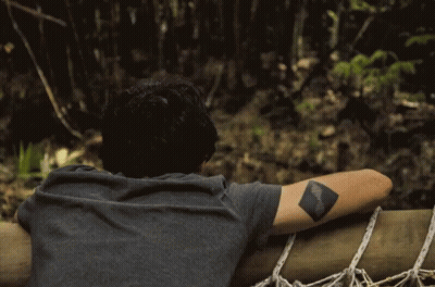 Man With Tattoo Looking Over Railing GIF