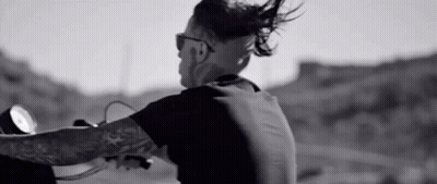 Man With Tattoo Riding Motorcycle On Road GIF