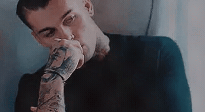 Man With Tattooed Arms Covering Mouth GIF