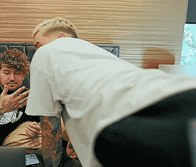 Man With Tattoos Kneeling Next To Another Man GIF