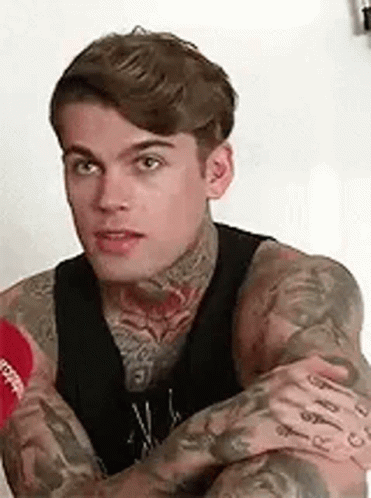 Man With Tattoos Sitting With Arms Crossed GIF