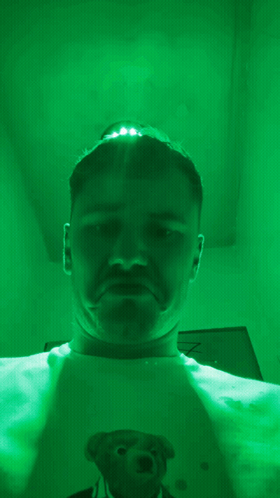Man With Teddy Bear Shirt Taking Selfie In Green Room GIF
