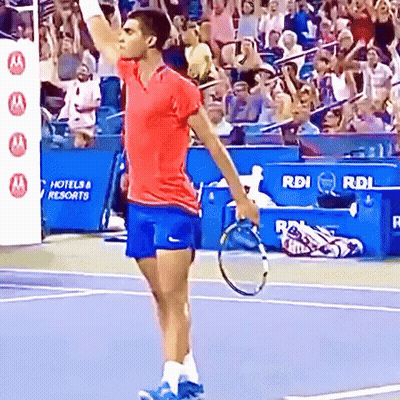 Man With Tennis Racquet In Front Of Hotel & Resorts Sign GIF