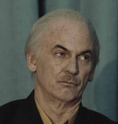 Man With White Hair and Mustache Making Funny Face in Suit