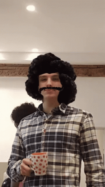 Man With Wig And Mustache Holding Cup GIF