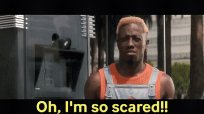 Man With Yellow Hair Standing In Front Of Scared Sign GIF