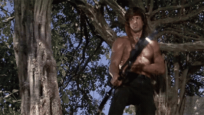 Man Without Shirt Holding Gun in Tree