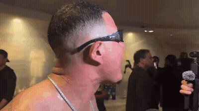 Man Without Shirt Holding Microphone In Front Of Crowd GIF