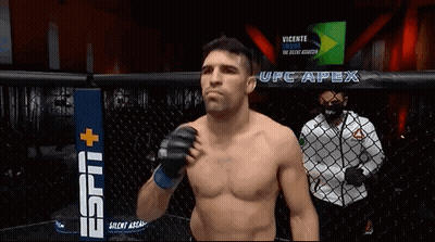 Man Without Shirt In Cage In Front Of UFC Apex Sign GIF