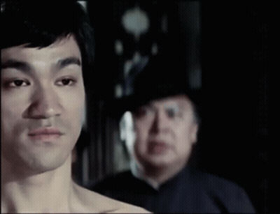 Man Without Shirt In Front Of Man In Hat GIF